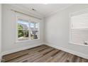 A sunlit bedroom with wood-look floors, neutral walls, and large windows at 1513 Armscroft Lane, Apex, NC 27502
