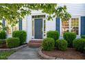 Elegant front entrance featuring a gray door with decorative glass and manicured shrubs at 1909 Redding Lane, Durham, NC 27712