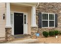 Close up of the entryway with stone accents and a black front door at 203 Green Pasture Rd, Mebane, NC 27302