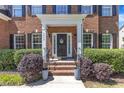 Charming front entrance with brick steps, decorative wreath, and manicured landscaping at 2049 Rainy Lake St, Wake Forest, NC 27587