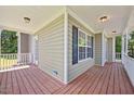 Relaxing covered porch with wood flooring, white railings and green siding at 210 Mediate Dr, Raleigh, NC 27603