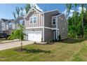 Craftsman style townhome with a one car garage, green lawn, and attractive landscaping at 212 Brook Farm Ln, Fuquay Varina, NC 27526