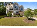 Two-story home with a manicured lawn and lush landscaping at 221 Hammond Wood Pl, Morrisville, NC 27560