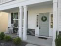 Inviting front porch with rocking chairs and a decorative wreath on the door at 222 Oak Branch Trl, Garner, NC 27529