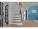Welcoming foyer with a staircase and bright blue accent wall, showcasing the home's classic details at 2306 Byrd St, Raleigh, NC 27608