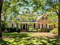 Charming two-story home featuring a welcoming front porch and a well-manicured lawn at 2405 Flints Pond Cir, Apex, NC 27523