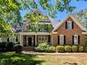 Charming two-story home featuring a welcoming front porch and a well-manicured lawn at 2405 Flints Pond Cir, Apex, NC 27523