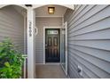 Covered porch with view of a black front door with glass, side panel and black door hardware at 2609 Asher View Ct, Raleigh, NC 27606