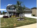 Beautiful two-story home featuring well-maintained lawn with a mature tree in the front yard on a sunny day at 267 Darecrest Ln, Wendell, NC 27591