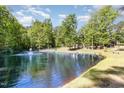 Scenic pond with a fountain feature surrounded by mature trees and lush greenery at 2913 Escondido Farm Rd, Garner, NC 27529