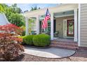 Inviting front porch with brick steps, an American flag, and a swing, perfect for relaxing outdoors at 30150 Walser, Chapel Hill, NC 27517