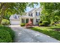 Traditional home with neat landscaping, including shrubbery and a Japanese maple tree, complemented by a covered front porch at 30150 Walser, Chapel Hill, NC 27517