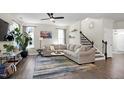 Bright living room with neutral decor, large sectional sofa, stylish rug, and staircase at 3017 Ginger Hill Ln, Durham, NC 27703