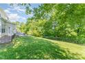 Large backyard with a well-maintained lawn, a fence, and mature trees offers a private outdoor space at 302 Red Elm Dr, Durham, NC 27713