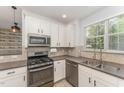 Bright kitchen with white cabinets, stainless steel appliances, and a large window offering natural light at 302 Red Elm Dr, Durham, NC 27713