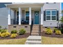 Close-up of a welcoming front porch with a blue door and decorative wreath at 3224 Wishing Well Wynd, Apex, NC 27502