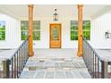 Front entrance with stone steps, black wrought-iron railings, wood pillars, and a beautiful wood door at 3281 Phillips Chapel Rd, Haw River, NC 27258