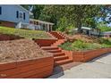 Beautifully landscaped front yard with tiered retaining walls and steps leading to the home at 3425 Brentwood Rd, Raleigh, NC 27604