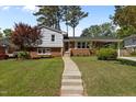 Charming home featuring a brick and vinyl exterior with a walkway and lush green lawn at 3501 Arrowwood Dr, Raleigh, NC 27604