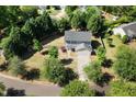 Aerial view of home with mature trees, fenced yard, and long driveway at 401 Onondaga Ct, Holly Springs, NC 27540