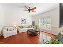 Bright living room with hardwood floors, a large window, and comfortable seating arrangement at 408 Blooming Meadows Rd, Holly Springs, NC 27540