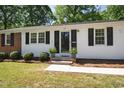 Inviting front entrance with a black door, symmetrical potted plants, and a well-manicured lawn at 430 Fenton St, Raleigh, NC 27604