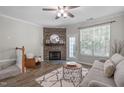 Cozy living room with a decorative fireplace, ceiling fan, and natural light at 4535 Sugarbend Way, Raleigh, NC 27606