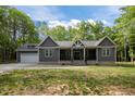 Charming exterior of a gray home featuring a covered porch and an attached garage at 5402 Shealtiel Way, Rougemont, NC 27572