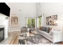 Bright living room with a fireplace, high ceilings, hardwood floors, and large windows at 5504 Creekdale Cir, Raleigh, NC 27612