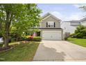 Classic two-story home featuring a two-car garage and lush landscaping at 5512 Bridgeman Ct, Durham, NC 27703