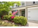 Inviting front porch adorned with vibrant landscaping and an American flag at 5512 Bridgeman Ct, Durham, NC 27703