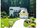 Beautiful two-story home with attached two-car garage and driveway with mature landscaping and green lawn at 624 Moultonboro Ave, Wake Forest, NC 27587