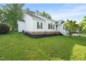 Charming home featuring clean white siding, black shutters, and a well-maintained lawn and landscaping at 6324 Daybreak Dr, Wake Forest, NC 27587