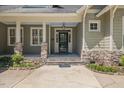 Inviting front entrance with stone pillars, landscaping, and a modern black front door at 6509 Mountain Brook Ln, Raleigh, NC 27615