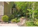 Lush side yard with stone pathway leading to a pool amidst mature trees and landscaping at 6509 Mountain Brook Ln, Raleigh, NC 27615