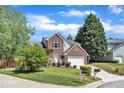A well-maintained two-story brick home with an attached two-car garage and a neatly landscaped front yard at 7 Bonham Ct, Durham, NC 27703