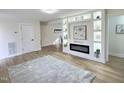 Bright living room features a modern fireplace with built-in display shelving and light hardwood floors at 707 Wade Ave, Raleigh, NC 27605