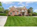 Elegant brick home features lush lawn and beautiful landscaping, creating curb appeal at 712 Evanvale Ct, Cary, NC 27518