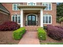 Welcoming front entrance with brick walkway, manicured bushes, and classic double doors at 712 Evanvale Ct, Cary, NC 27518