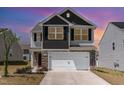 Two-story home with two-car garage, stone accents and grey and black siding at 729 Little Patch St, Zebulon, NC 27597