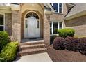 Elegant front entrance with a white door and brick facade at 7508 Venture Ct, Raleigh, NC 27615
