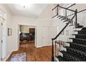 Grand foyer with hardwood floors, staircase, and view into office with french doors at 800 Oxbow Crossing Rd, Chapel Hill, NC 27516