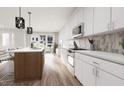 Modern kitchen featuring white cabinets, stainless steel appliances, and a stylish island with wood accents at 803 Fireship Rd, Fuquay Varina, NC 27526