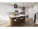 Open-concept kitchen with a central island, modern pendant lighting, and seating for four at 803 Fireship Rd, Fuquay Varina, NC 27526
