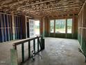 Unfinished Living room showing the framing and construction stage, with a door leading outside at 803 Fireship Rd, Fuquay Varina, NC 27526