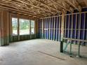 Spacious unfinished room showing the framing and construction stage, with view of a large window at 803 Fireship Rd, Fuquay Varina, NC 27526