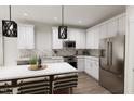 Modern kitchen features stainless steel appliances, stylish countertops, and sleek white cabinetry at 805 Fireship Rd, Fuquay Varina, NC 27526