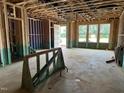 Bright, unfinished living room featuring a large window and door to the outside at 805 Fireship Rd, Fuquay Varina, NC 27526