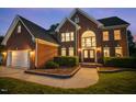 Charming brick home with an attached two-car garage, complemented by manicured landscaping and a paved walkway at 817 Highwater Pl, Fuquay Varina, NC 27526
