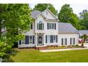 Charming two-story home with a well-maintained lawn and surrounded by lush greenery at 8600 Clivedon Dr, Raleigh, NC 27615